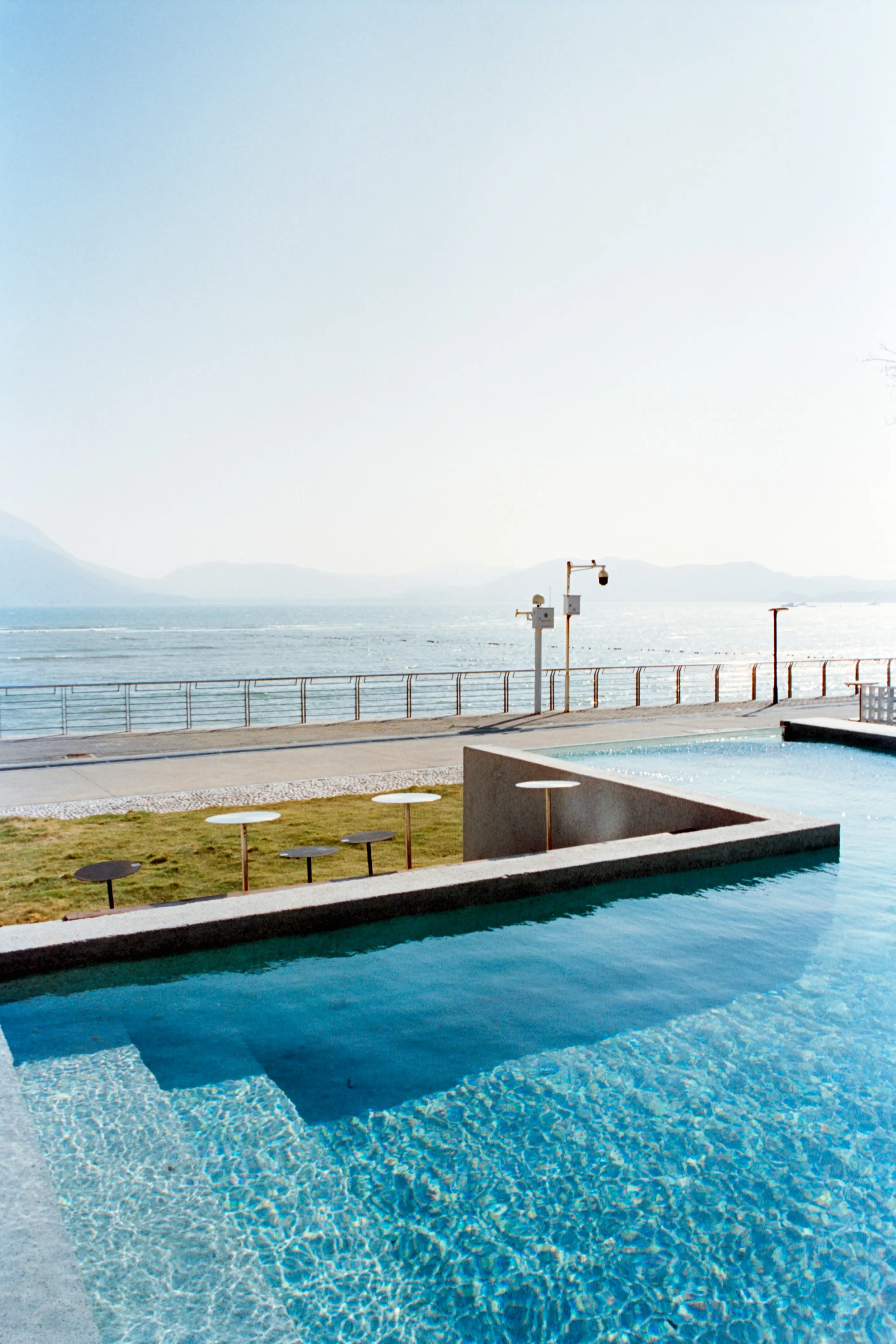 Luxury resort pool overlooking calm ocean and mountains